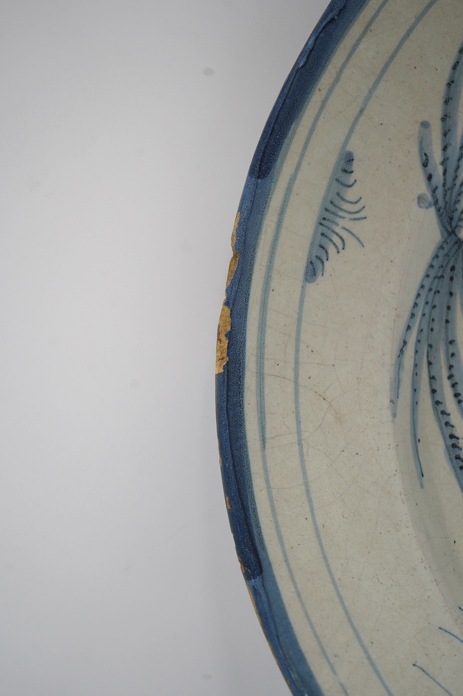 An 18th century Dutch Delft blue and white charger, diameter 33.5cm. Condition - poor, large crack running across half the diameter of the plate and through to the base, as well as some chips to the rim including one lar